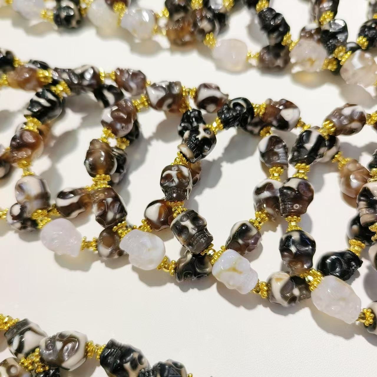 Detailed view of skull beads, natural stones, and gold-tone accents