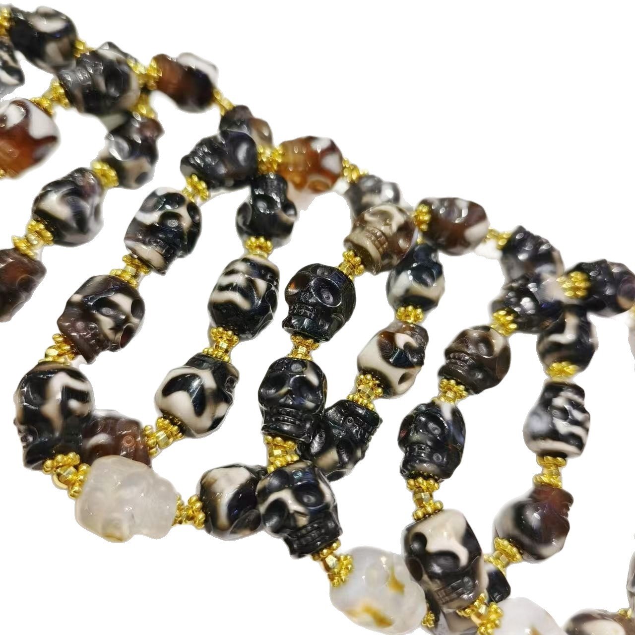 Close-up of handcrafted agate skull bracelet with gold-tone spacers